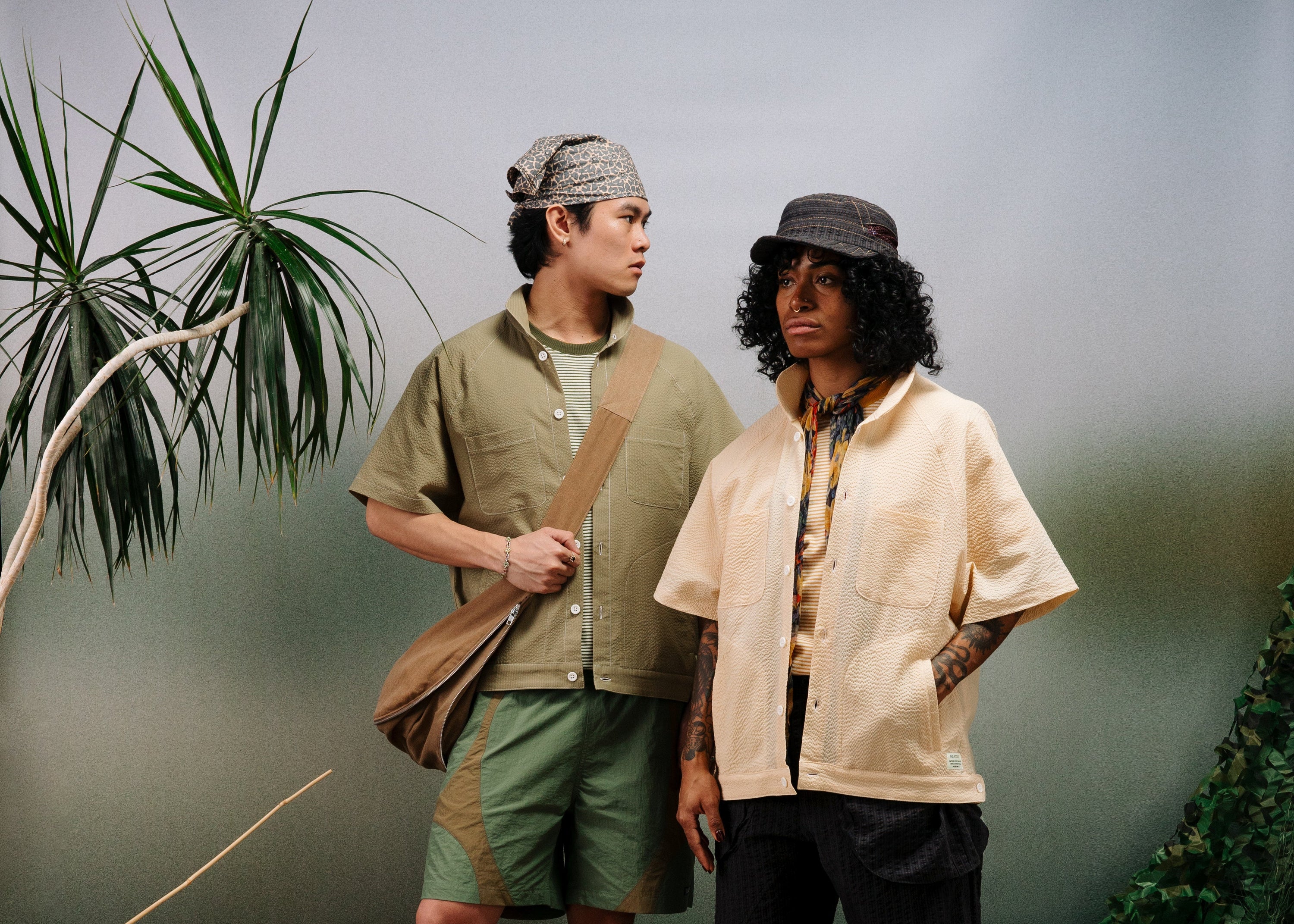 Two people standing outdoors with a natural background